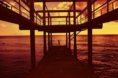 Pier on sea at sunset