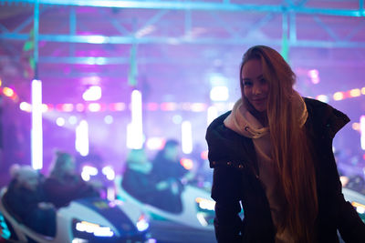 Woman standing against illuminated stage at music concert