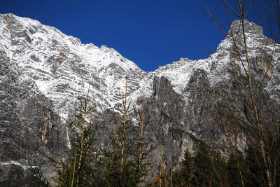 Low angle view of snowcapped mountains against clear sky