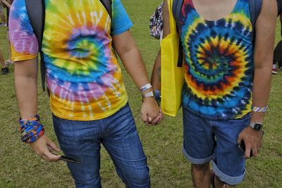 Rear view of two people standing on grassland