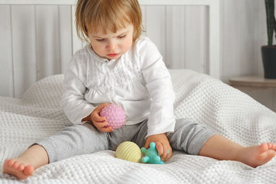 Baby girl playing tactile knobby balls. young child hand plays sensory massage ball