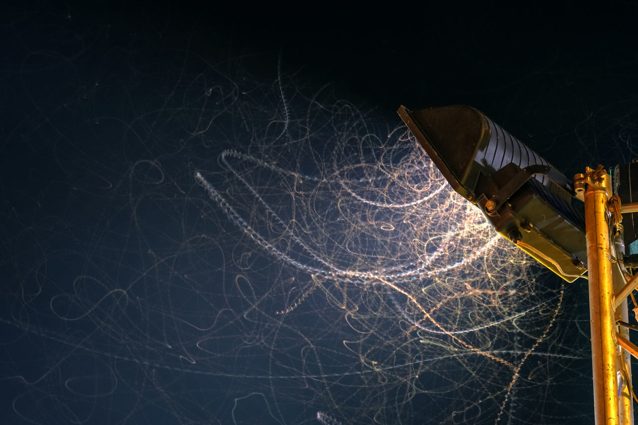 LOW ANGLE VIEW OF ILLUMINATED LIGHTING EQUIPMENT AT NIGHT