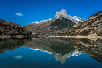 Scenic view of lake and mountains against blue sky