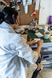 Side view of woman using laptop at home