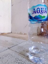 Close-up of glass bottle on tiled floor