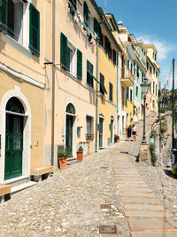 Footpath amidst buildings against sky