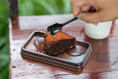 Close-up of hand holding ice cream on table