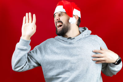 Young man with hat on red background