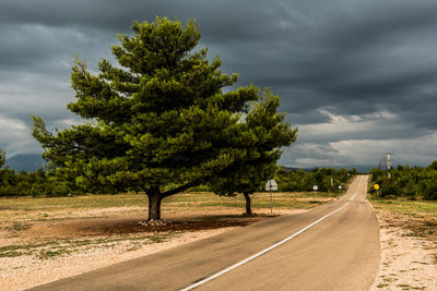 Empty road against cloudy sky