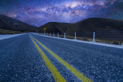 Road by mountains against sky