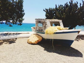 Boat moored on beach against clear sky