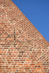 Low angle view of brick wall against sky