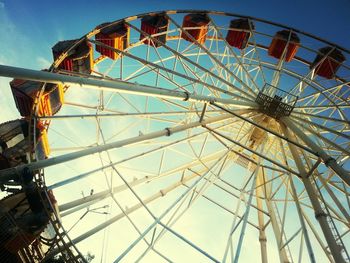 Low angle view of ferris wheel against blue sky