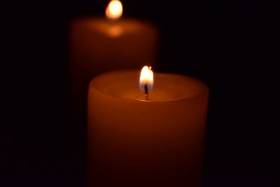Close-up of lit candle in dark room