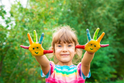 Portrait of cute girl holding toy against trees