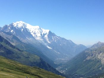 Scenic view of snowcapped mountains against clear blue sky