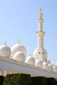 Low angle view of mosque against clear blue sky