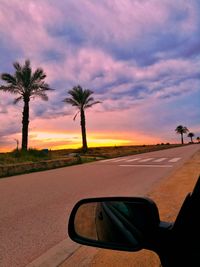 Close-up of car on road against sunset sky