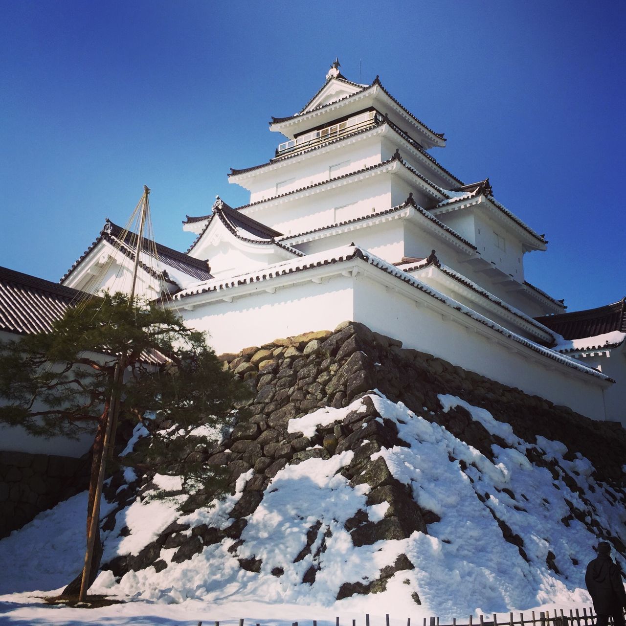 building exterior, architecture, built structure, clear sky, low angle view, snow, blue, winter, cold temperature, religion, copy space, place of worship, sunlight, day, outdoors, season, bird, travel destinations, spirituality, no people