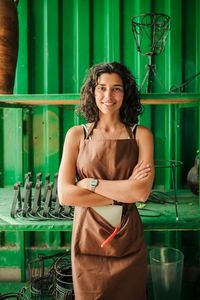 Portrait of cheerful female potter in pottery shop