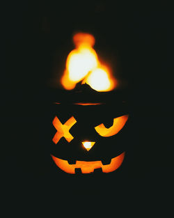 Close-up of illuminated jack o lantern against black background