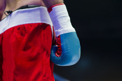 Midsection of shirtless boxer standing in boxing ring