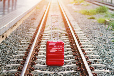 Red luggage on railroad track