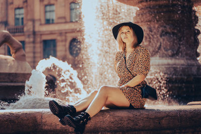 Full length of woman sitting outdoors