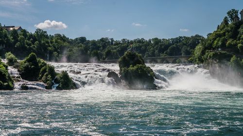 Scenic view of waterfall against sky