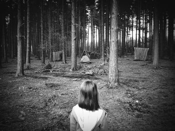 Rear view of girl at campsite in forest