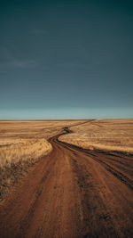 Road amidst field against sky