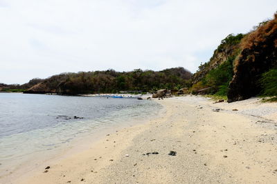 Scenic view of beach and mountains against sky