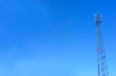 Low angle view of communications tower against clear blue sky