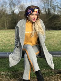 Portrait of young woman standing on field