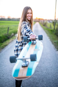 Portrait of young woman using mobile phone on road