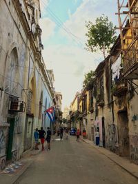 People walking on street amidst buildings in city