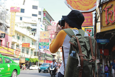 Rear view of woman standing on street in city