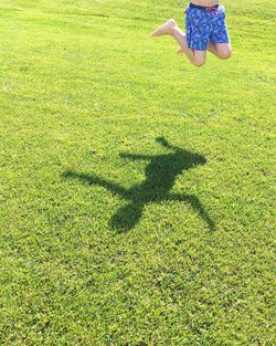 Low section of boy jumping on field