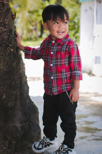 Portrait boy in red flannel shirt posing with a smile