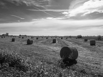 Hay bales on field against sky
