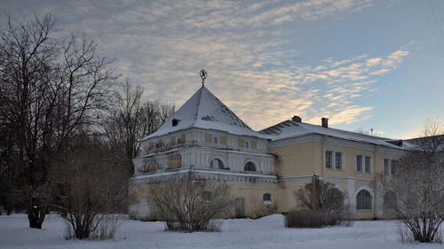 Houses on field against sky during winter