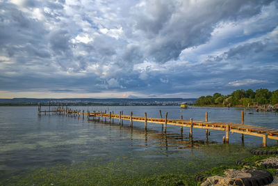 Wooden posts on beach against sky