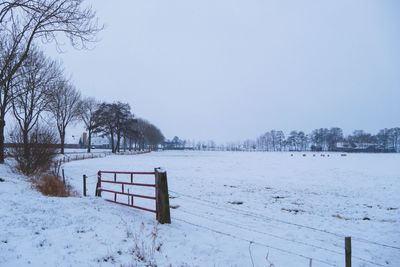 Scenic view of snow covered field against sky