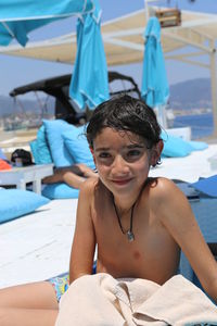 Portrait of shirtless boy sitting on beach