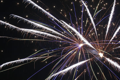 Low angle view of firework display at night