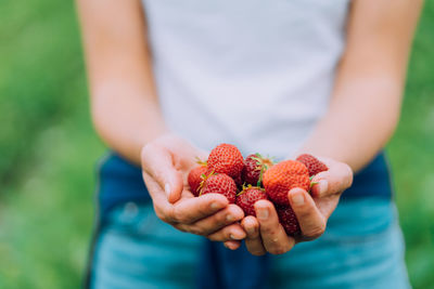 Midsection of man holding strawberry