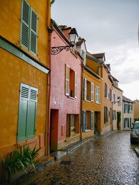 Residential buildings by street against sky