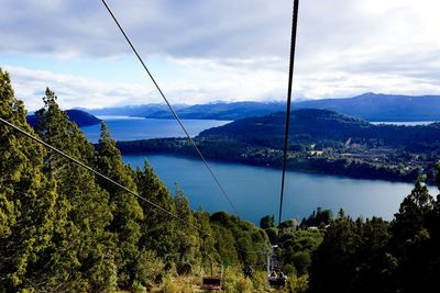 Overhead cable cars against lake