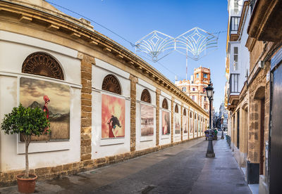 Street amidst buildings against blue sky