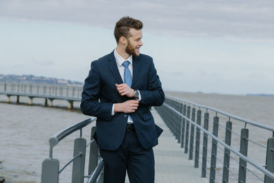 Full length of young man standing against railing